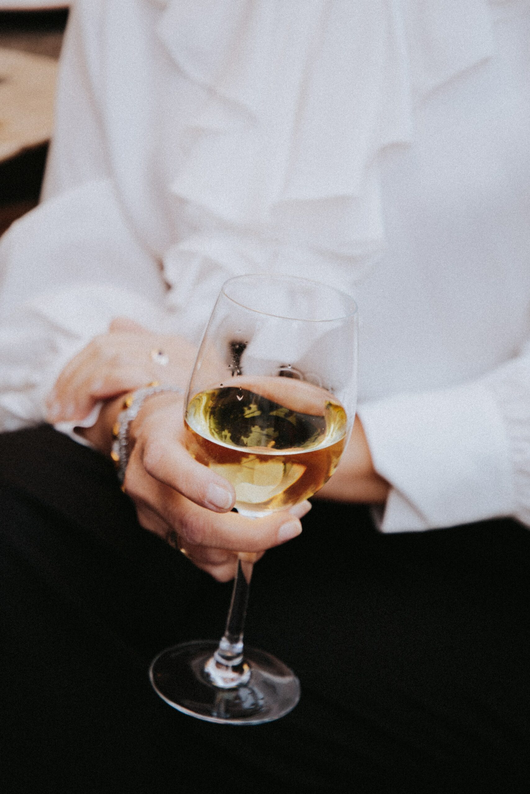 man in white shirt holding a glass of english wine