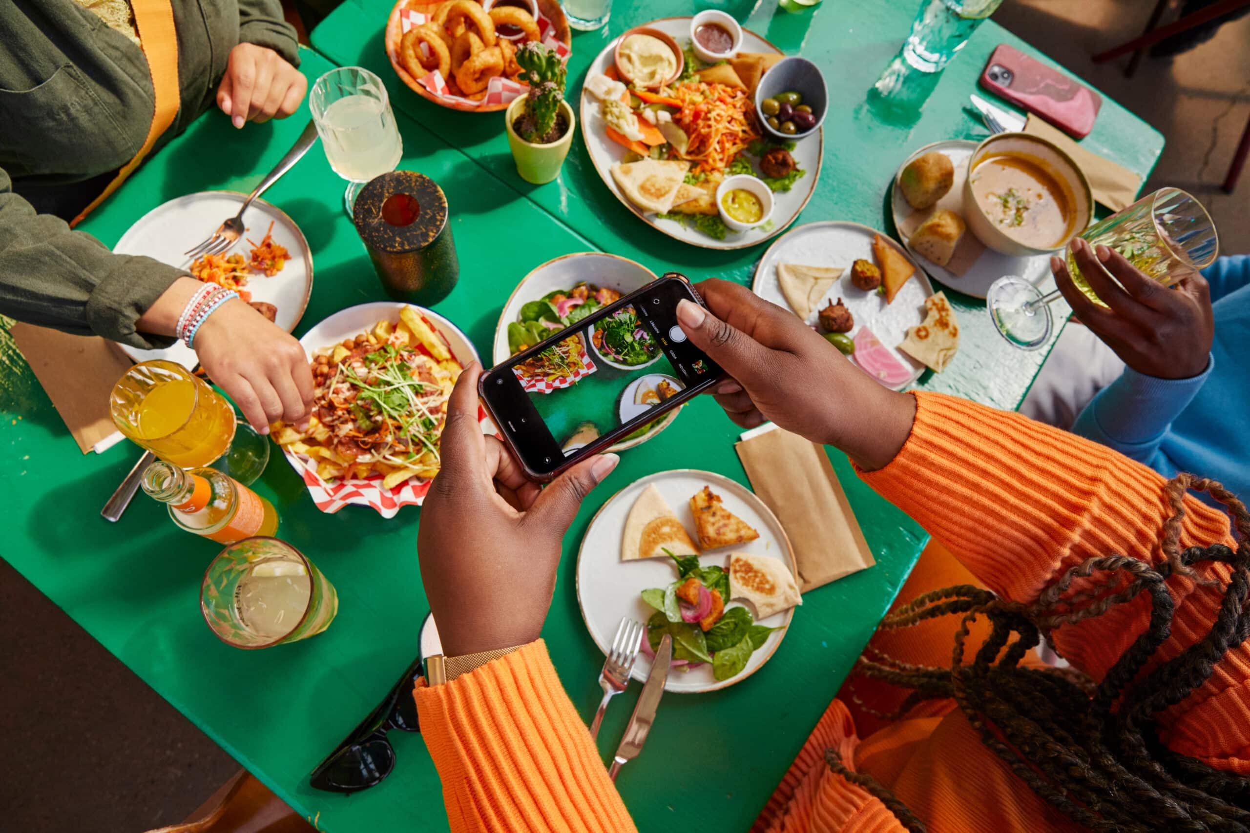 people at table taking photos of food